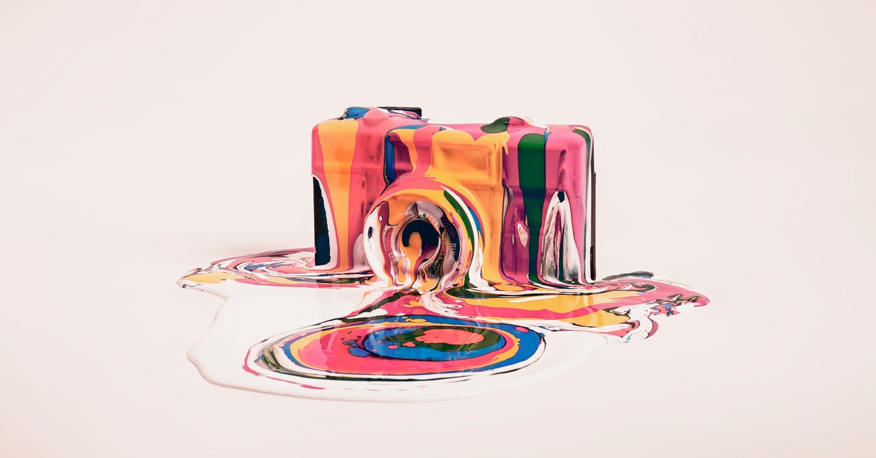 A colorful melting camera with vibrant paint around it.