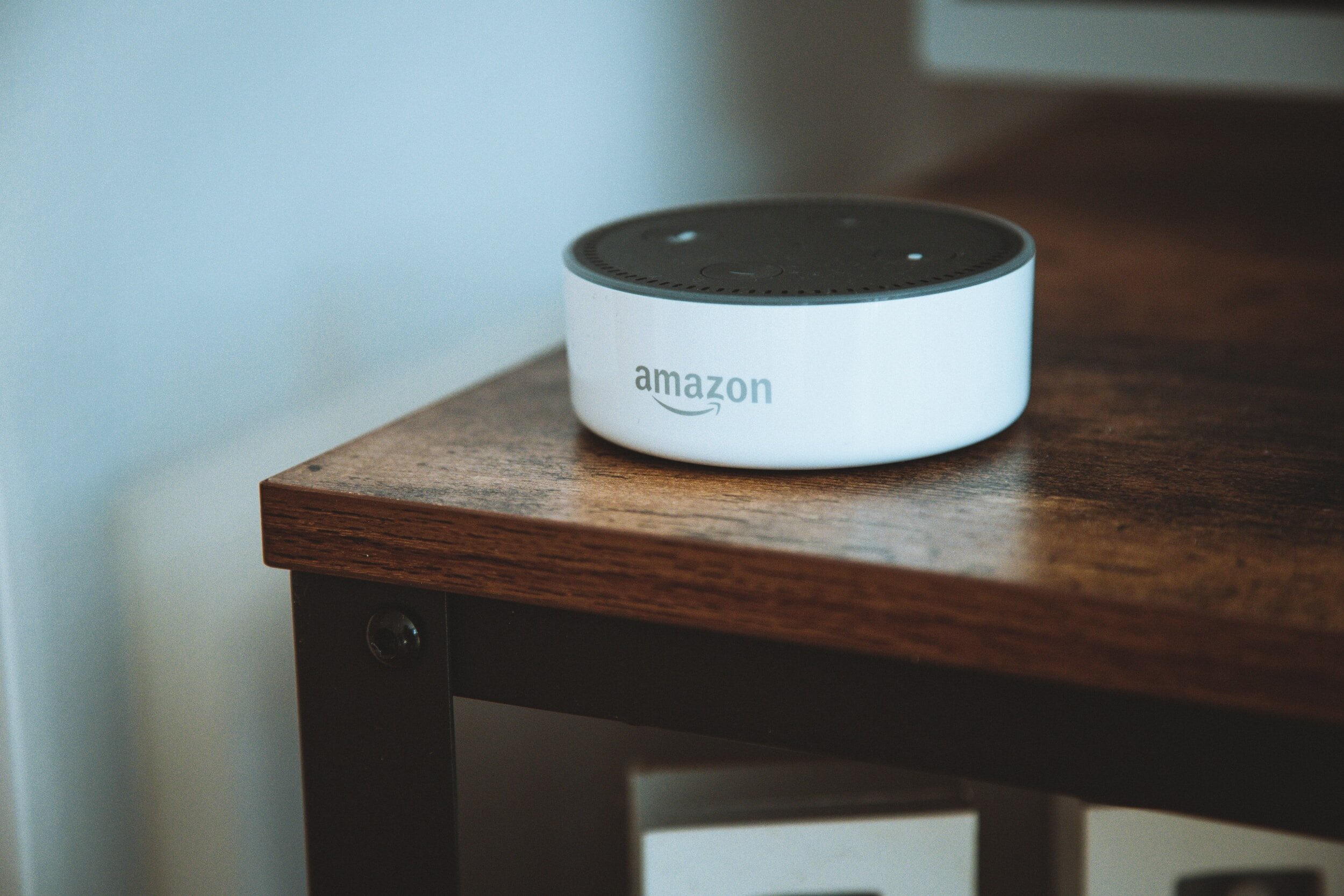 A voice-activated Amazon assistant on a wooden surface.