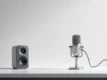 A sleek, minimalist desktop setup featuring a microphone and speaker on a clean background, representing voice AI and digital interactions.