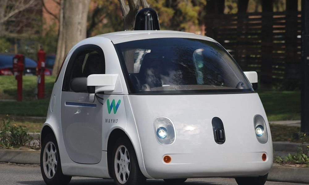 Futuristic self-driving car with Waymo logo in suburb