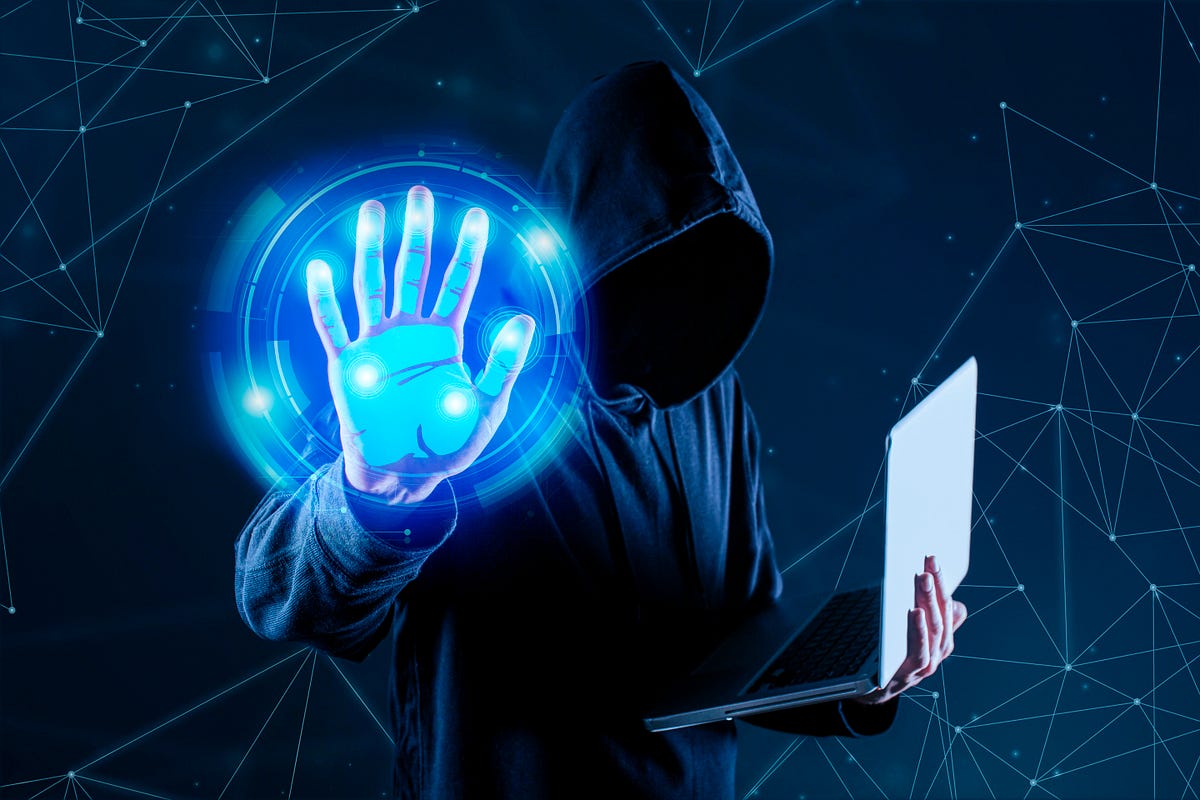 A figure in a hooded sweatshirt holds a laptop and displays a glowing handprint.