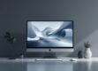 A clean, minimalist desktop workspace with a computer monitor displaying an abstract, futuristic visualization.