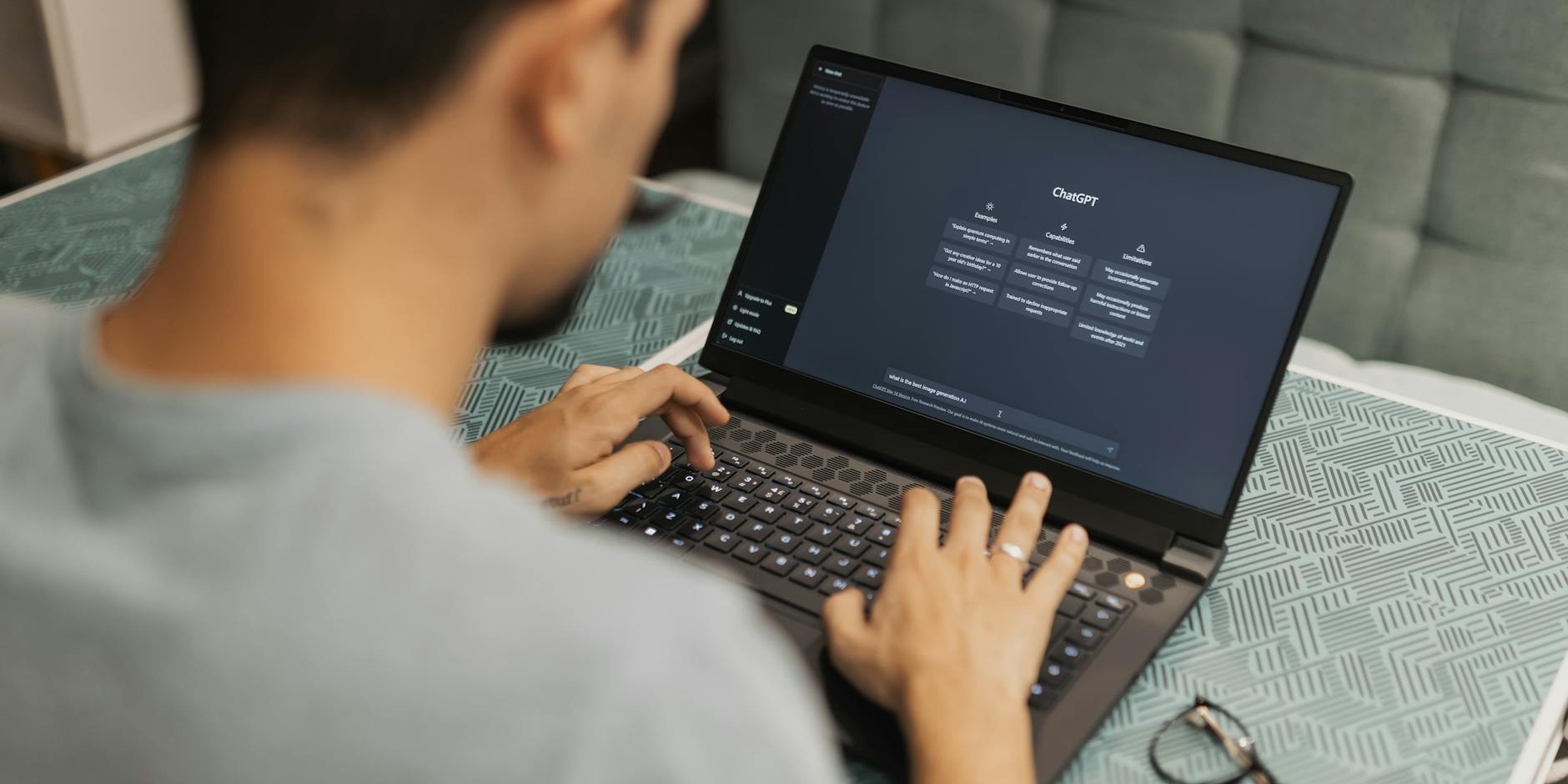 A person typing on a laptop with a dark AI interface.