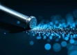 A sleek, metallic key transforming into binary code particles, illuminated by blue light against a dark background.