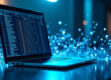 A modern desk setup with a laptop showing a spreadsheet and holographic data visualizations.